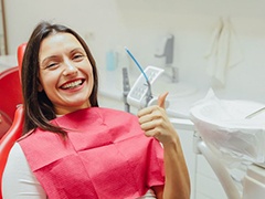 Happy dental patient making thumbs up sign