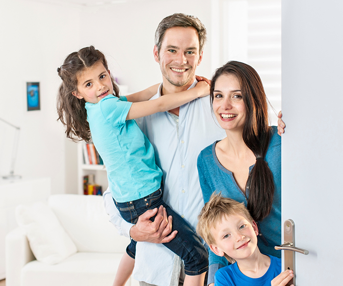 Family of four smiling in their living room after visiting Anthem dentist in Torrance