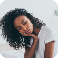 Woman wincing and holding the side of her jaw in pain