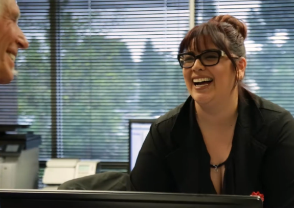 Dental team member laughing with a patient