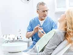 A dentist showing a jaw model to his patient