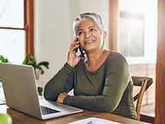 Woman smiling while talking on phone at home