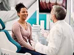 Smiling patient talking to dentist