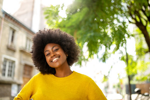 Woman in yellow shirt standing outside smiling